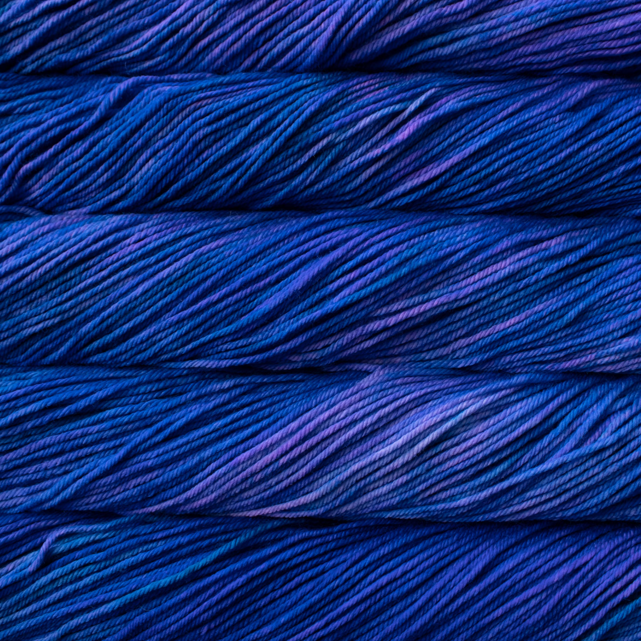 A close-up image of a skein of blue yarn with purple tonal colors.